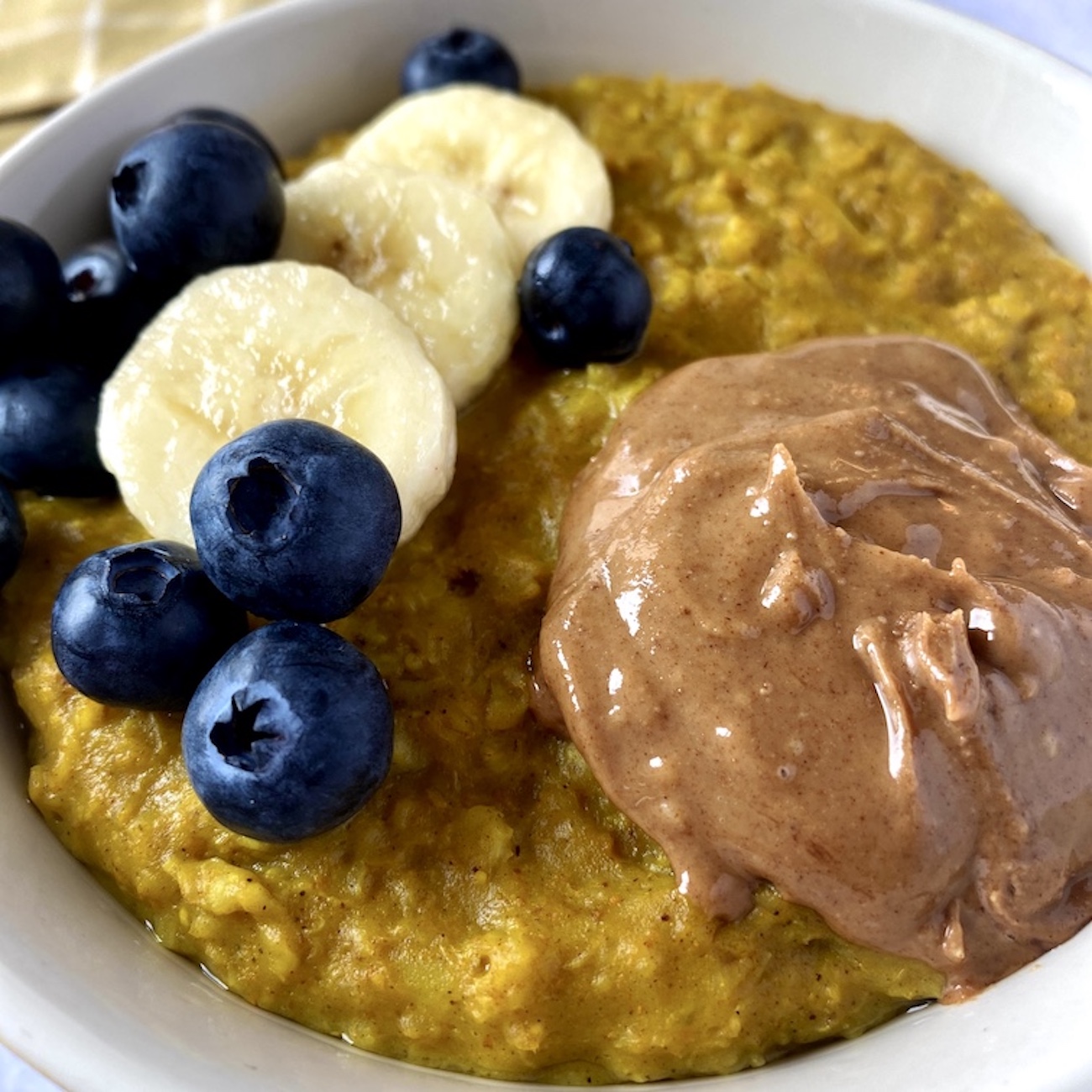 Kurkuma-Porridge mit Banane, Blaubeeren und Mandelmus
